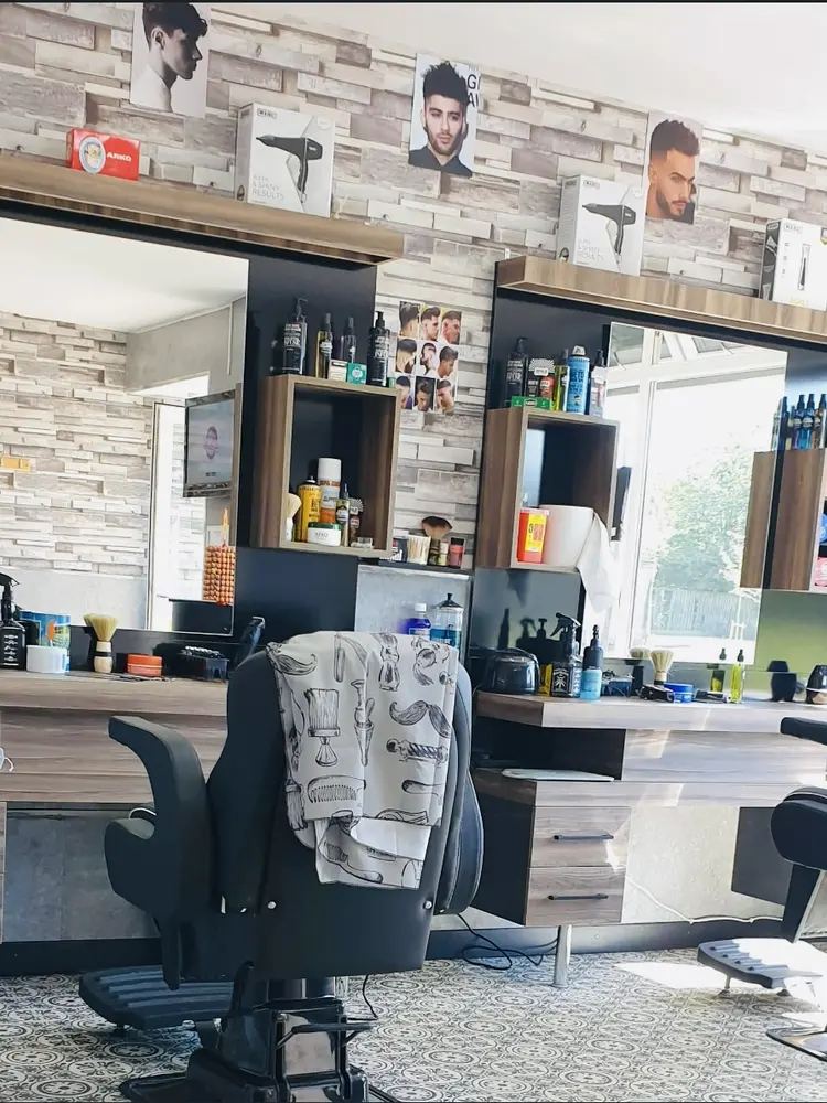 Interior of HB Barbershop with two barber chairs, wide mirrors and shelves of styling products